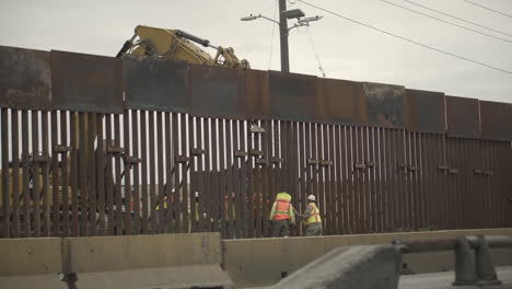 A-construction-crew-works-on-a-new,-bigger,-border-wall-with-the-U