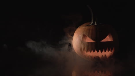 Halloween-pumpkin-on-black-background-with-smoke-puff,-Apple-Pro-Res