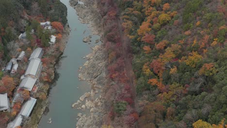 Japanischer-Tempel-Im-Arashiyama-Gebirgsfluss-Mit-Luftaufnahme-Der-Herbstfarben