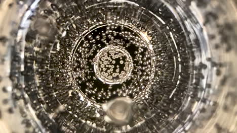 Slow-motion-and-extreme-close-up-shot-of-a-glass-of-champagne-bubbles-moving-up-to-the-surface-and-exploding