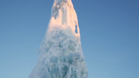 Tall-iceberg-inside-small-town-in-northern-sweden,-panning-shot-during-sunrise