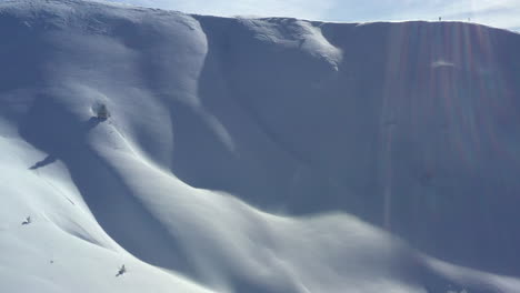 Luftaufnahme,-Die-Einen-Schneebedeckten-Berghang-Hinauffliegt-Und-Eine-Bergsilhouette-Hinter-Dem-Bergrücken-Zeigt