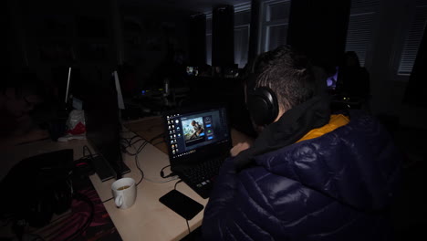 Static-shot,-of-a-man-playing-games,-gaming-on-his-computer,-with-headphones-on,-at-a-LAN-party,-in-south-Norway