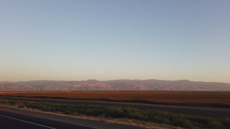 Driving-to-Los-Angeles-with-mountains-in-the-valley-in-the-distance-at-sunset