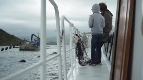 SLOWMO---Kids-standing-on-boat-deck-and-looking-at-New-Zealand-greenshel-mussel-farm