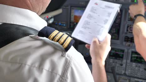 Airline-Pilots-in-Uniform,-Close-Up-Cockpit-Flight-Checklist,-4K