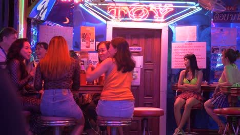 Bar-girls-in-Soi-Cowboy-sitting-outside-the-Toy-Bar,-waiting-for-customers