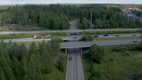 Still-aerial-view-of-a-motorway-overpass-as-two-people-walk-under-the-bridge