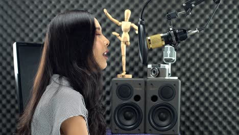 Asiatische-Teenager-Frau,-Die-Schwarzes-Langes-Haar-Umwickelt,-Singt-Laut-Ein-Lied-Mit-Power-Sound-über-Hängendem-Mikrofon-Kondensator-Und-Ausrüstung