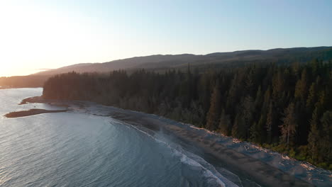 Drone-over-a-beach-and-trees-on-Vancouver-Island-in-Sooke,-British-Columbia-Canada-at-sunset