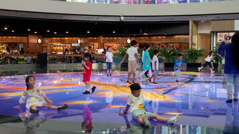 Kinder-Vergnügten-Sich-Mit-Bunten-Lichtern-Auf-Dem-Boden-Im-Marina-Bay-Sands-Singapur