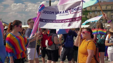 Colorful-people-getting-ready-to-march-in-the-Budapest-Pride,-Ladies-holding-banners
