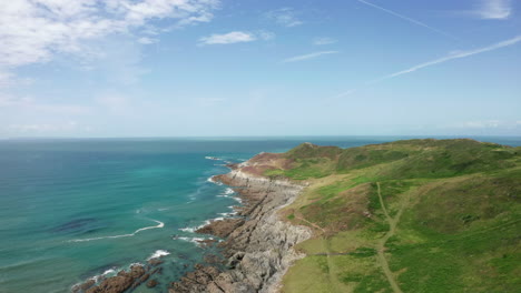 Rising-Aerial-Shot-of-a-Coastal-Headland-in-North-Devon-on-a-Summer’s-Day