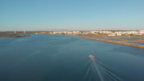 Motor-boat-cruising-on-Arade-River-a-beautiful-sunny-day,-aerial-long-shot