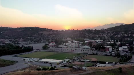 Stunning-hyper-lapse-of-the-sun-going-down-behind-the-mountains-with-athletic-fields-int-he-foreground