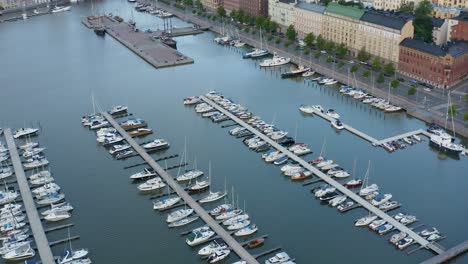 Slow-aerial-pan-up-of-dock-in-port-city-of-Helsinki,-Finland-at-dusk
