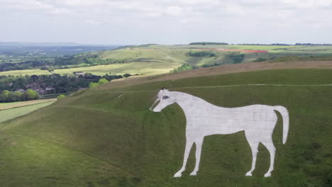 Aerial-Counterclockwise-Orbit-of-the-Westbury-White-Horse-on-a-Summer’s-Day-with-Hikers-Walking-Around-Perimeter-of-Horse-with-Narrow-Crop