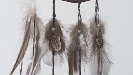 Hanging-Feathers-From-Dreamcatcher-Swaying-Side-To-Side-Against-Plain-White-Background