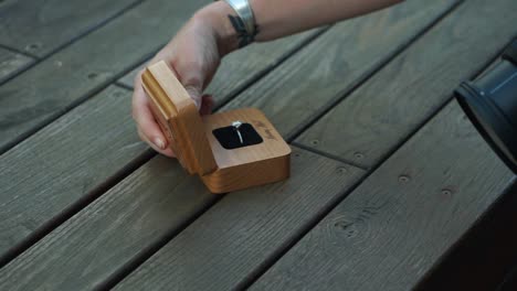 Isolation-shot-of-a-engagement-ring-box-as-a-photographer-handles-it