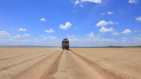 Modified-Toyota-Land-Cruiser-drives-away-on-flat-desert-sand-road