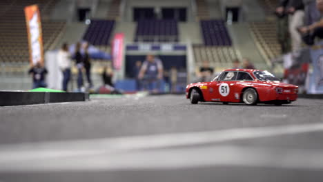 Small-red-RC-car-on-the-track-drifting-into-a-left-turn
