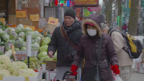Menschen-Tragen-Gesichtsmasken,-Während-Sie-Auf-Einem-Markt-Im-Freien-Obst-Und-Gemüse-Kaufen
