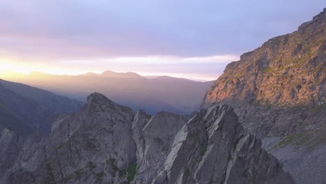 Picos-Montañosos-Escarpados-Y-Crestas-Estrechas-Y-Afiladas-En-Lo-Alto-De-Las-Montañas-De-Rumania-Con-Un-Impresionante-Cielo-De-Puesta-De-Sol-Lleno-De-Púrpura-Y-Rojo