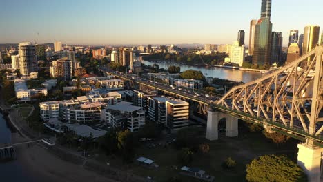 Amanecer-De-La-Ciudad-De-Brisbane-Hermosa-Antena-Con-Cbd,-Río-Brisbane,-Edificios,-Puente-De-Historia-Y-Numerosos-Autos-En-La-Carretera