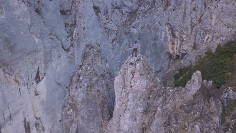 Climber-stands-on-high-peak-after-ascending-and-looks-out-on-amazing-landscape-of-Turda-Gorge-on-Sky-Fly-section-of-Via-Ferrata