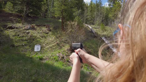 Woman-Fires-handgun-into-mountain-side