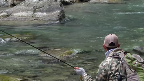 Trout-fly-fishing-in-mountain-river-at-summer