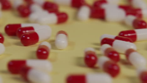 Nahaufnahme-Einer-Einzelnen-Pille-In-Zeitlupe,-Während-Mehrere-Pillen-Vorbeirollen-Und-Sie-Aus-Dem-Bild-Schieben