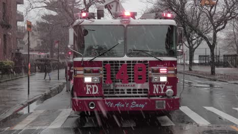 New-York-Fire-Department-Fire-engine-with-flashing-lights-under-snowfall---Wide-shot