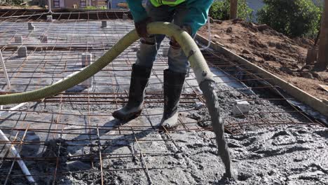 Concrete-is-poured-into-foundation-frame-full-of-rebar-and-electrical