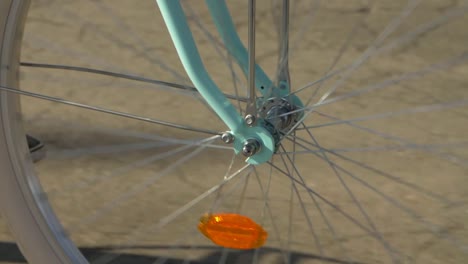 Revolving-front-wheel-of-a-turquoise-bicycle