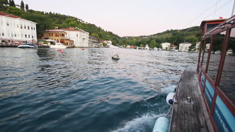 Türkisches-Holzboot-Segelt-Auf-Dem-Welligen-Marmarameer-Als-Touristenattraktion-Und-Fährt-Unter-Freiem-Himmel-An-Küstenvillen-Am-Wasser-Vorbei
