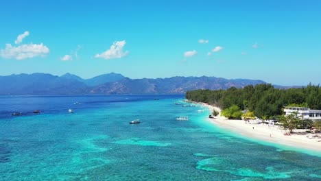 Beautiful-vacation-destination-with-white-sandy-beach-near-resort-and-trees-forest,-washed-by-crystal-emerald-water-of-turquoise-lagoon,-Indonesia