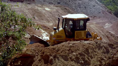 A-bulldozer-pushes-mounds-of-dirt-while-excavating-a-large-construction-site