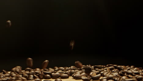 Kaffeebohnen-Fallen-Von-Oben-Auf-Eine-Holzoberfläche