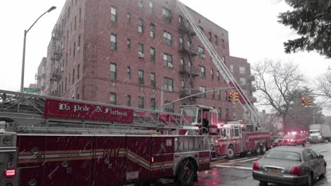 FDNY-using-fire-engine-ladder-to-reach-and-attend-to-fire-on-rooftop-building---Wide-Tilt-up-shot
