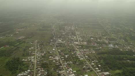 Remote-suburban-town-on-edge-of-Java-rainforest-on-overcast-day,-aerial