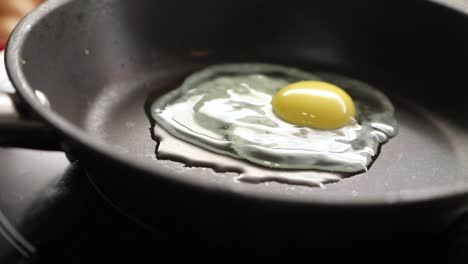 Chef-Frying-Egg-On-Skillet-Pan-In-Kitchen