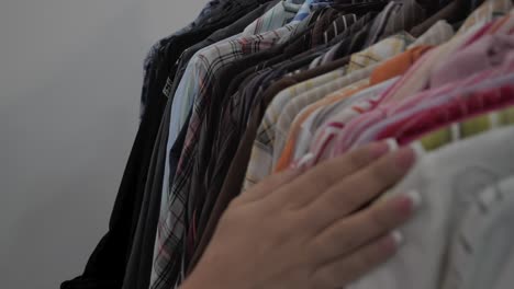 Woman's-hand-crosses-over-the-shirts-hung-on-the-hanger