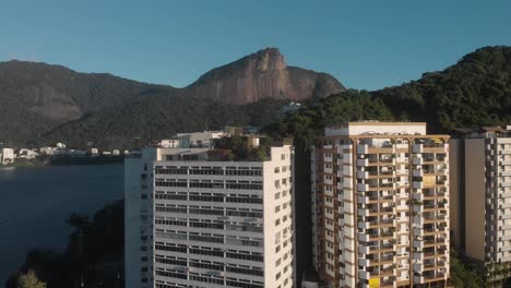 Aerial-descent-with-high-rise-residential-apartment-buildings-at-the-city-lake-Lagoa-Rodrigo-de-Freitas-in-Rio-de-Janeiro-with-the-Corcovado-mountain-in-the-back-at-sunrise