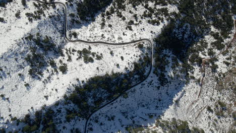 Aerial-view-of-winding-road-in-snowy-mountains