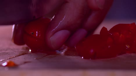 Close-up-video-of-the-hands-of-a-man-cutting-cherry-tomatoes-on-a-chopping-board