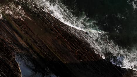 4K-drone-aerial-shot-of-a-cliff-and-waves-in-the-coastline-sea-in-Zumaia,-Spain