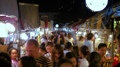 Moving-through-Crowded-night-market-food-stalls-in-slowmotion,-Bangkok