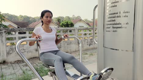 A-beautiful-woman-doing-chest-workout-in-an-outdoor-gym-in-Thailand---Mid-shot