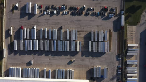 parking-area-with-lush-truck-containers-and-cars-in-carriers-company-branch,-Bird’s-eye-view